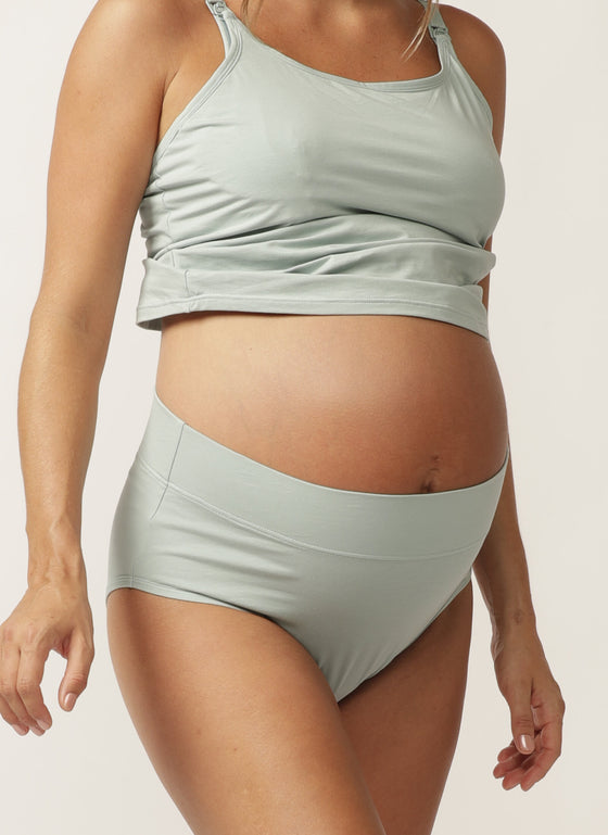 Close up of a pregnant model wearing a sage green nursing cami and matching full brief with wide waist band
