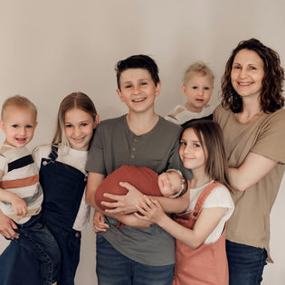  Matchy Mumma founder Chantelle pictured with her six children. Everyone is smiling and happy.