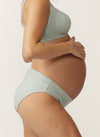 Side view of pregnant model wearing a blue gum nursing bra and matching bikini briefs