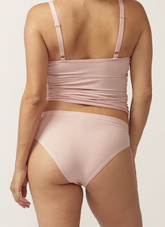 Back view of pregnant model wearing a soft pink nursing cami and matching bikini briefs