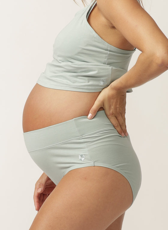 Side view of pregnant model wearing a sage green nursing cami and matching full brief with wide waist band