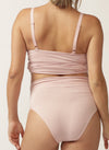 Back view of pregnant model wearing soft pink nursing cami and matching full brief with wide waist band
