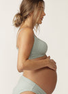 Side view of pregnant model wearing sage green nursing bra with matching briefs