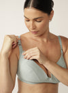 Close up of model unclipping sage green nursing bra 